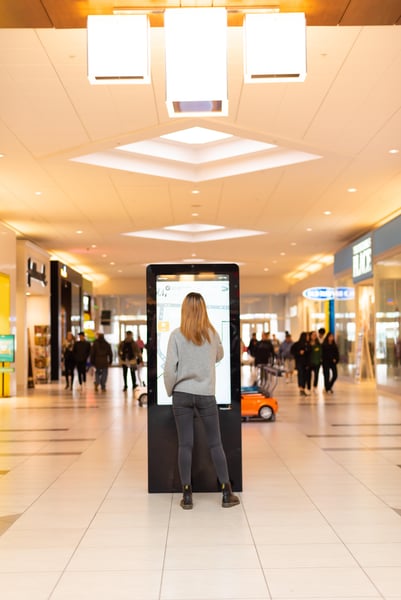 Woman at a digital directory in a mall