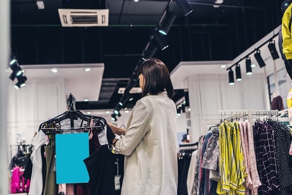 Woman standing in a store looking at clothing